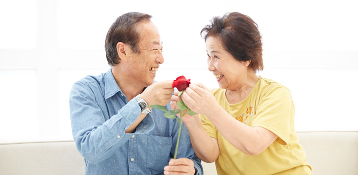 赤いバラを持つ熟年夫婦