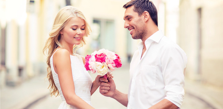 男性が女性にプロポーズで花束を渡すシーン