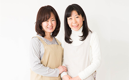 エプロンをつけた二人の女性