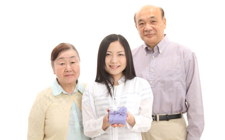 熟年夫婦とプレゼントを持った若い女性