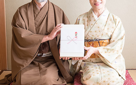 お歳暮を持つ老夫婦