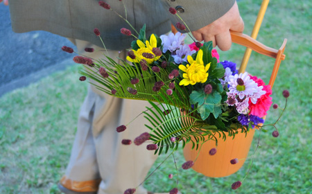 花桶に入ったお供えの花を運ぶ